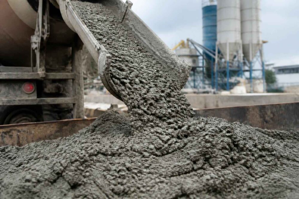 Świeża mieszanka betonowa z betonomieszarki Strumień świeżej mieszanki betonowej wysypuje się z betonomieszarki na placu budowy